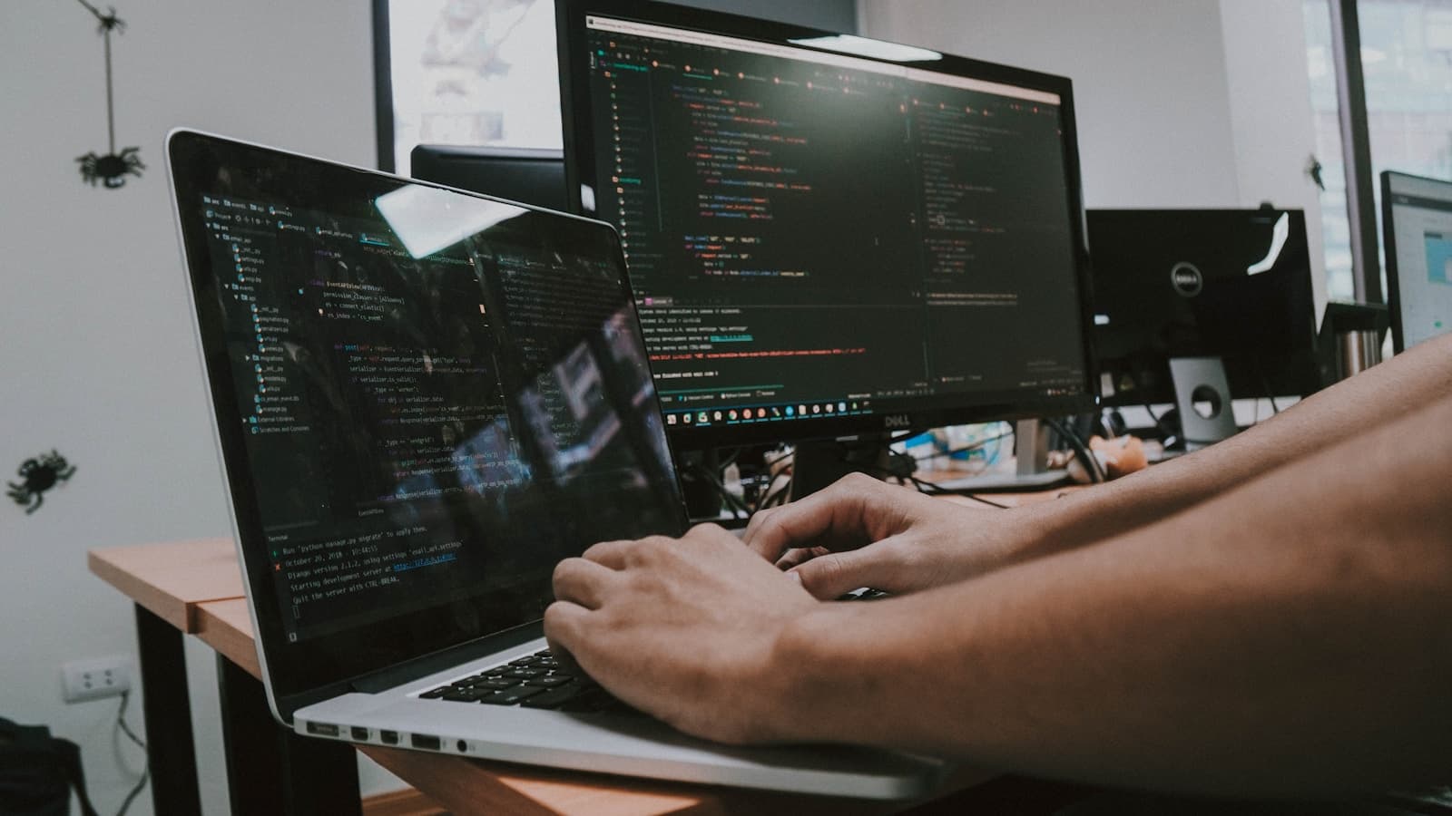 Developer working across multiple code-filled screens